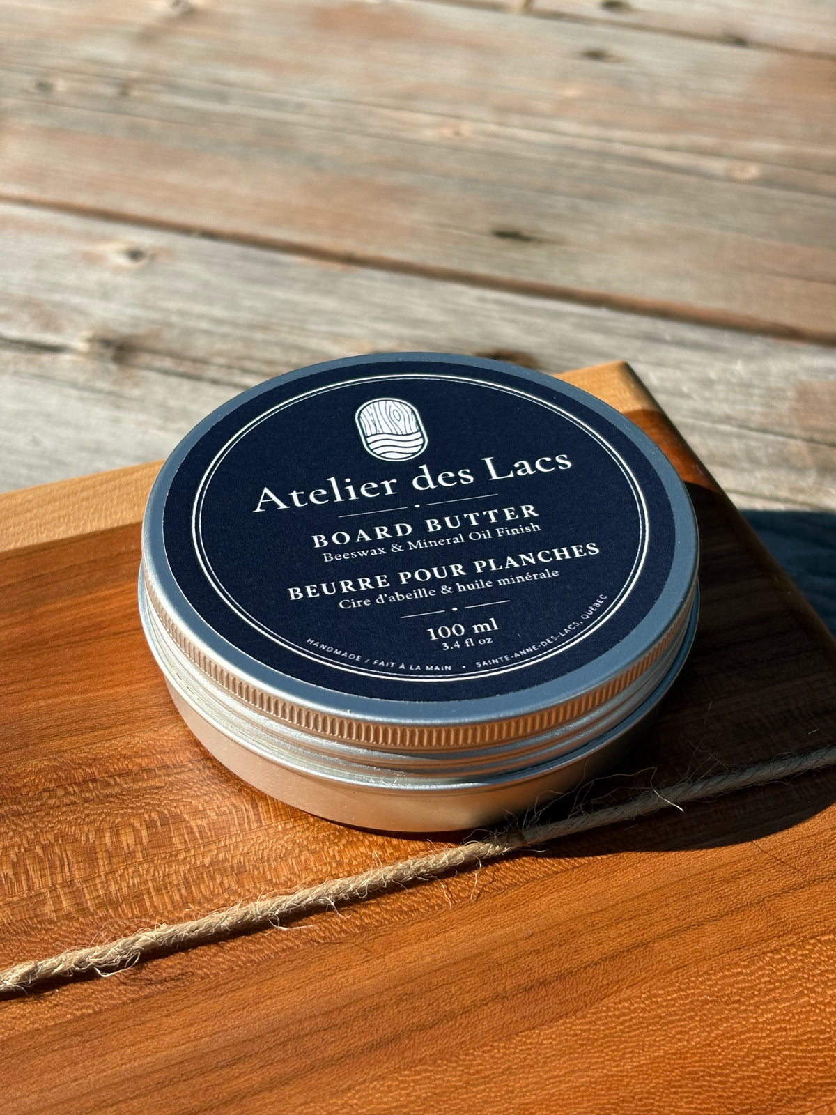 Tin of board butter resting on a wooden cutting board